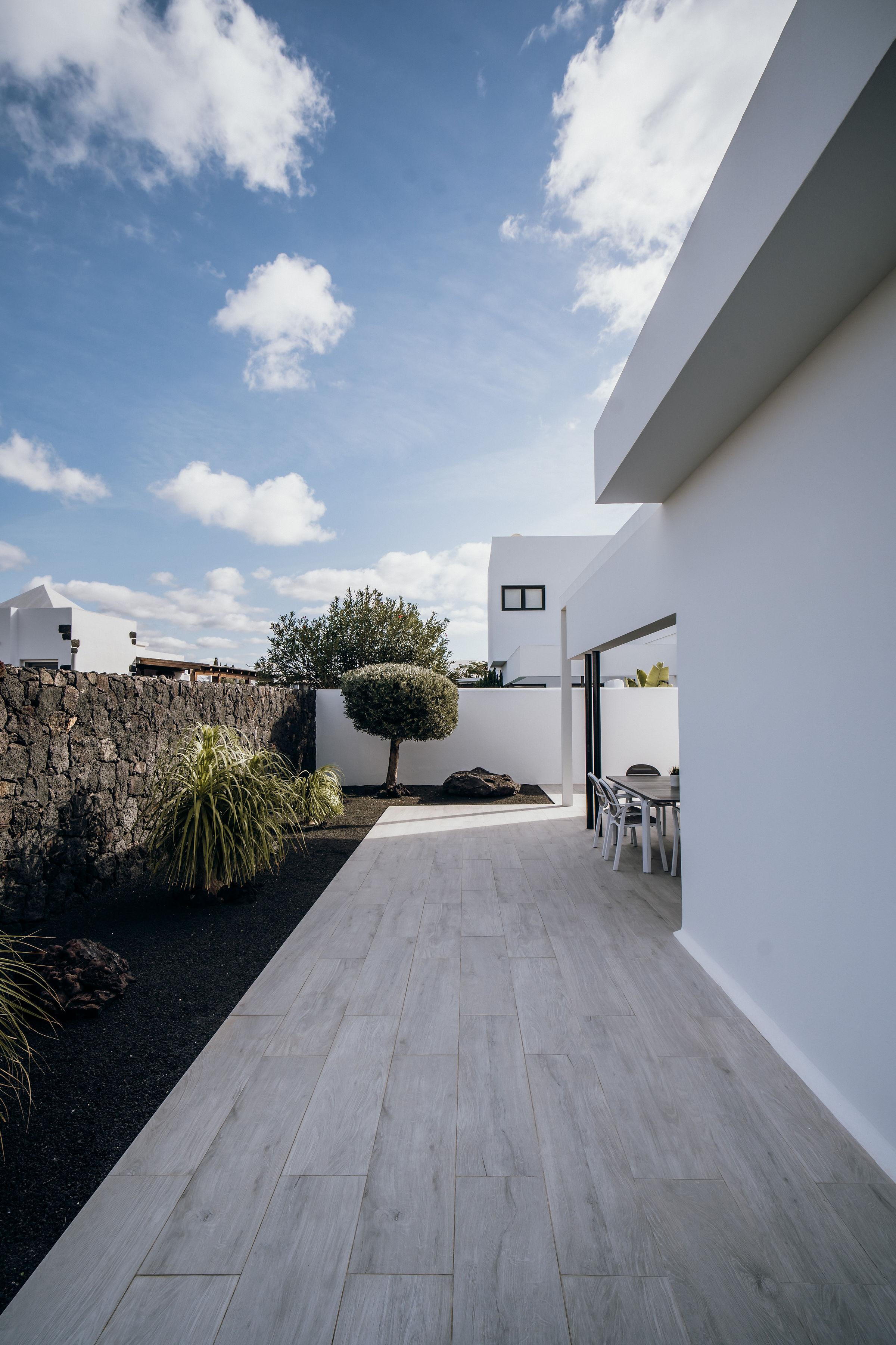Pasillo lateral con jardín de piedra volcánica