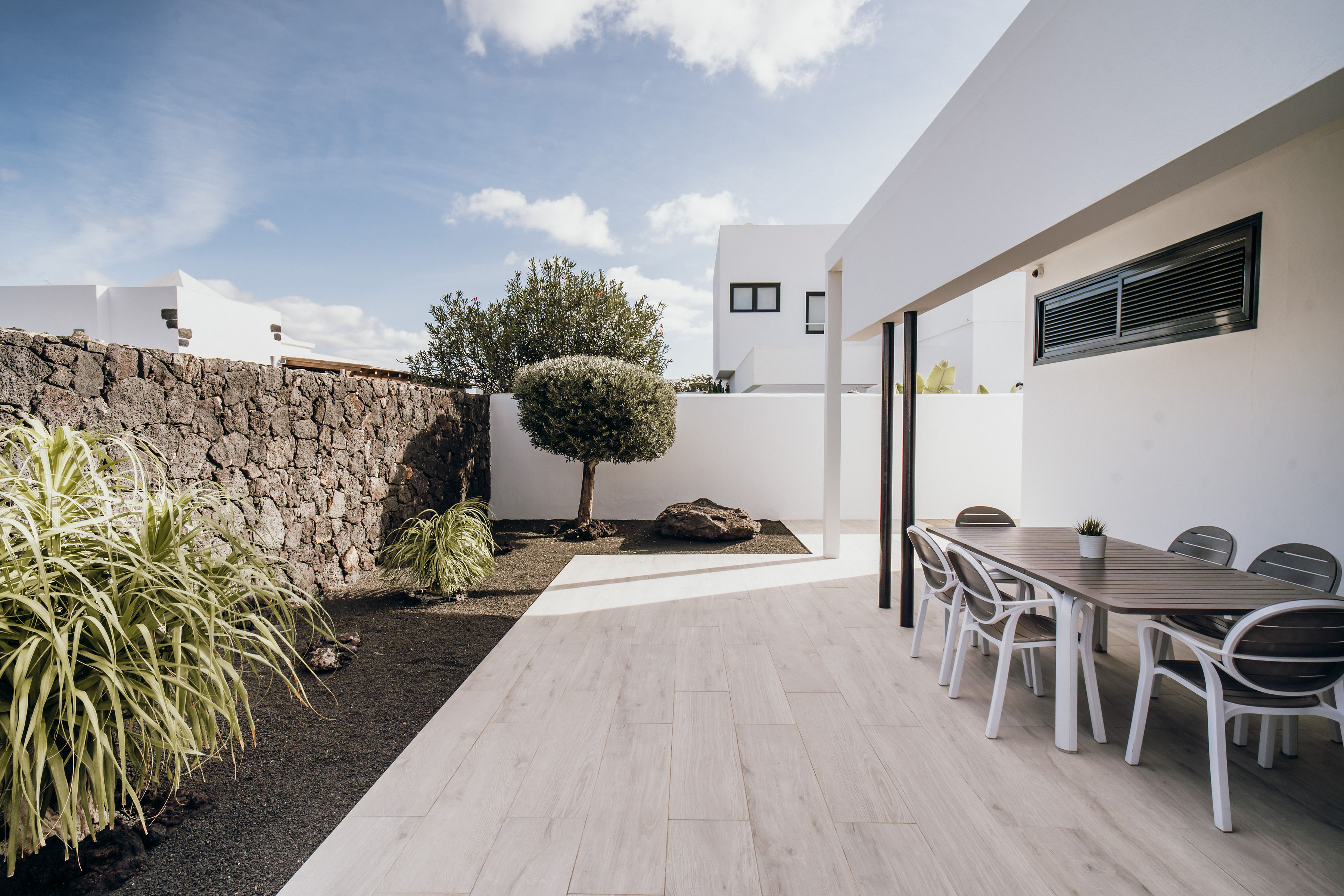 Terraza con mesa y sillas junto al olivo