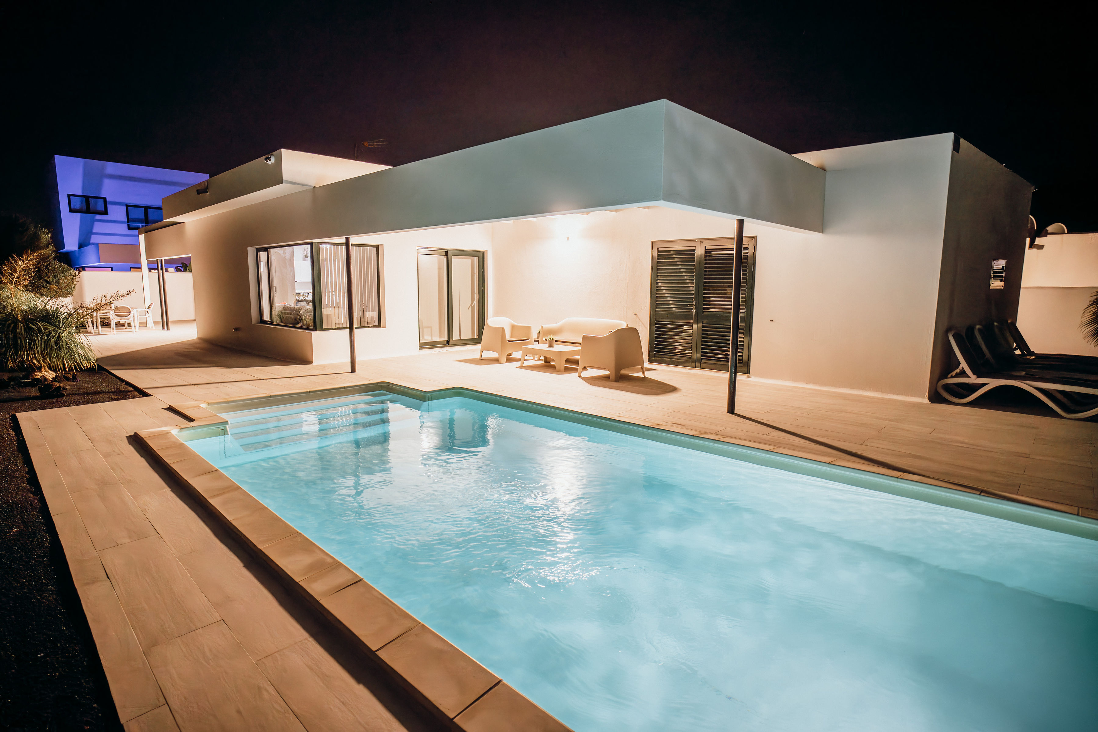 Villa Lava Dreams iluminada de noche, con piscina